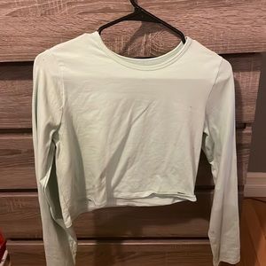 Light blue green, thin, crop top, long sleeve.